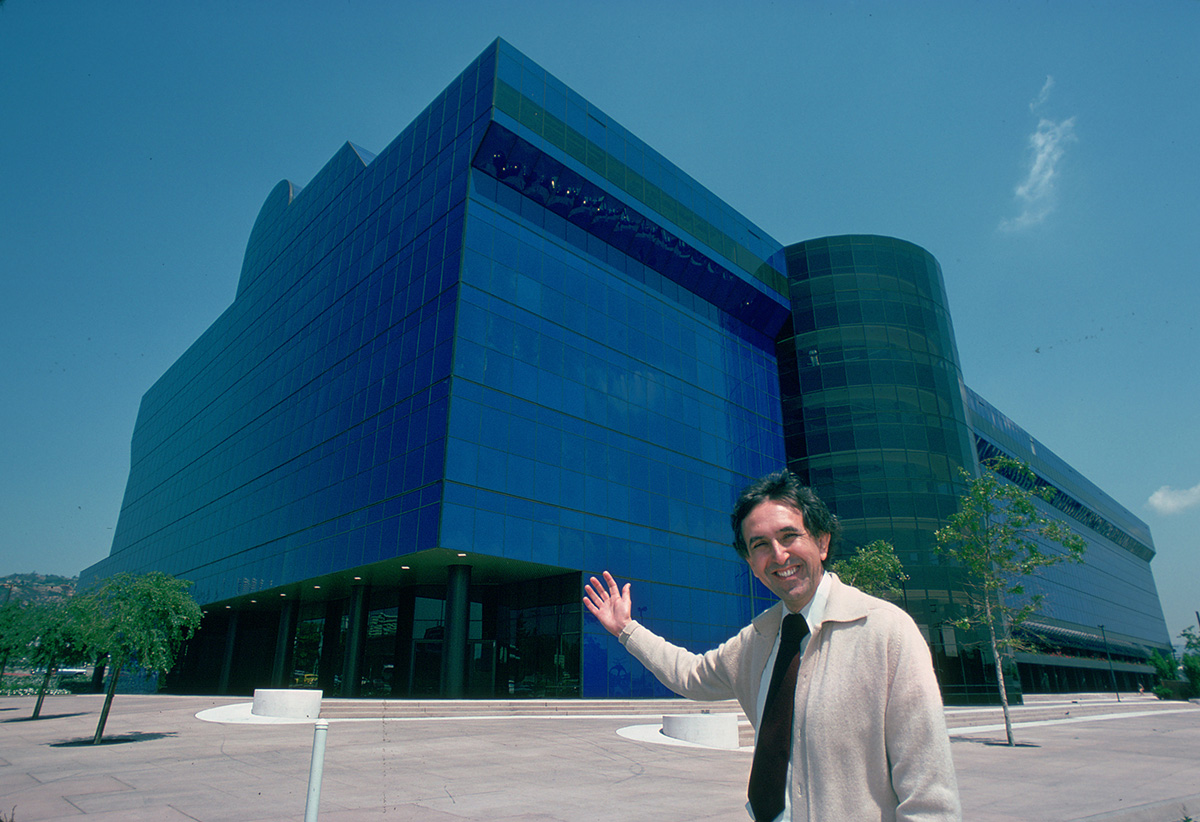 Image of man in front of blue glass building