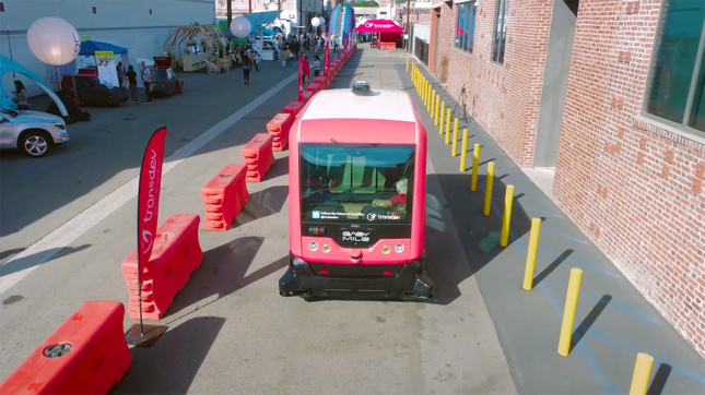A red-and-white autonomous shuttle at CoMotion