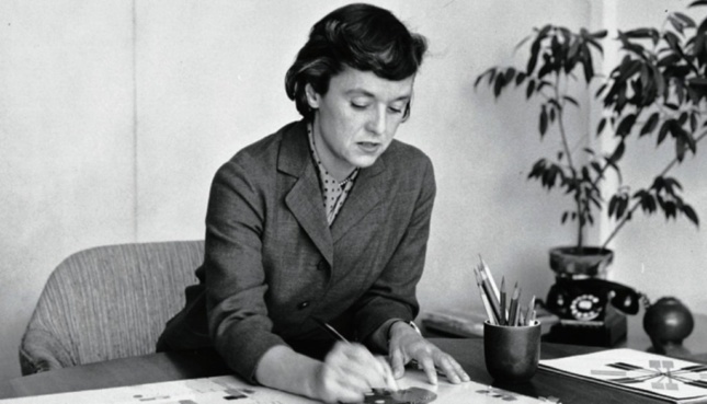 Black and white image of woman designing at a table 