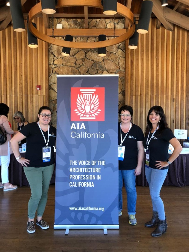 Conference goers by a banner that reads AIA California