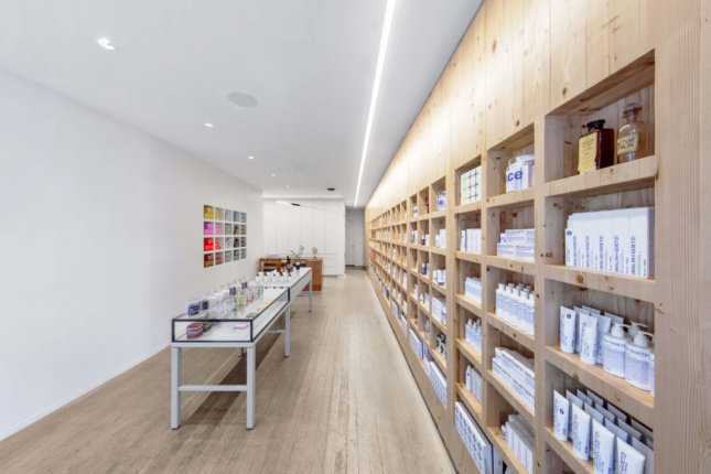 Interior photo of a linear retail store with timber shelving in a Malin + Goetz store