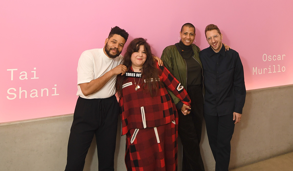 A group portrait of four people against a pink background at the turner prize awards