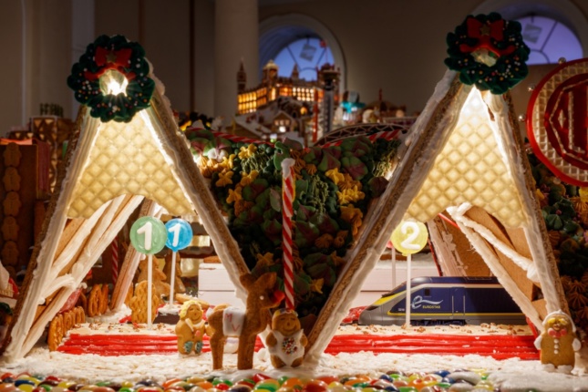a gingerbread train station with a miniature working train passing through