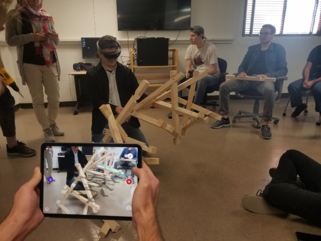 People in VR headsets interacting with wood structures