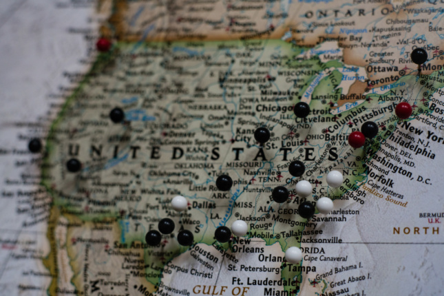 A map of the United States with black and white pins stuck into it