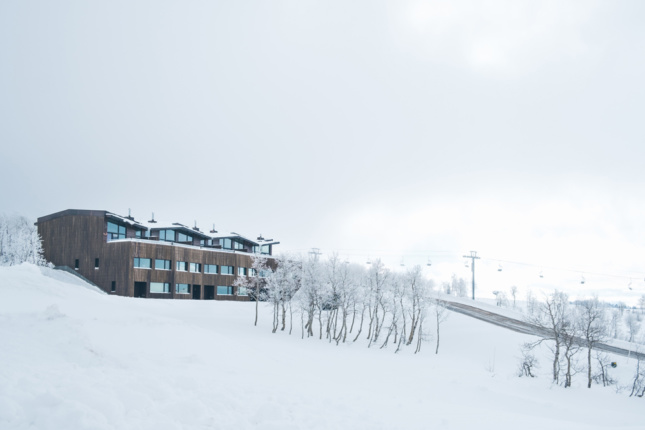 Exterior of a building atop a snowy hill. 