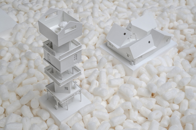 Model of a white tower erupting from packing peanuts