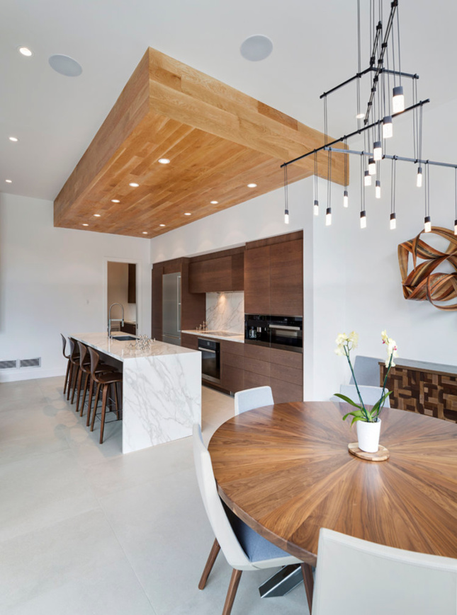 Interior shot of a kitchen island, dining room table, and chandelier