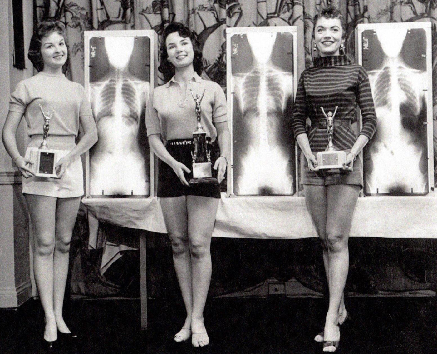 Black-and-white photo of three women with trophies, from X-ray architecture