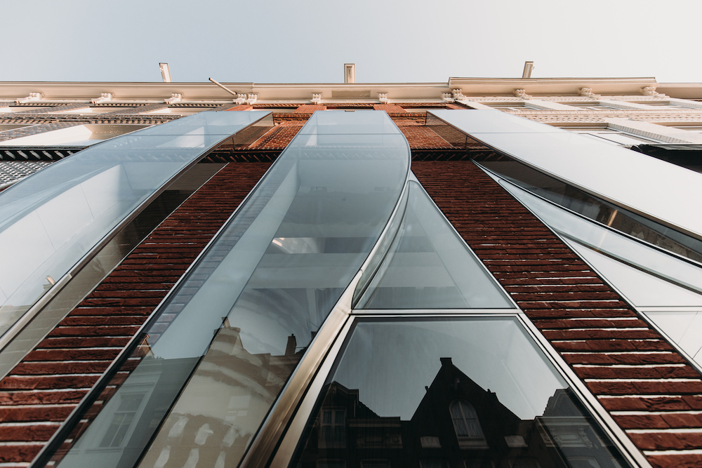 Detail of The Looking Glass facade looking upward, rivulets of glass running down brick