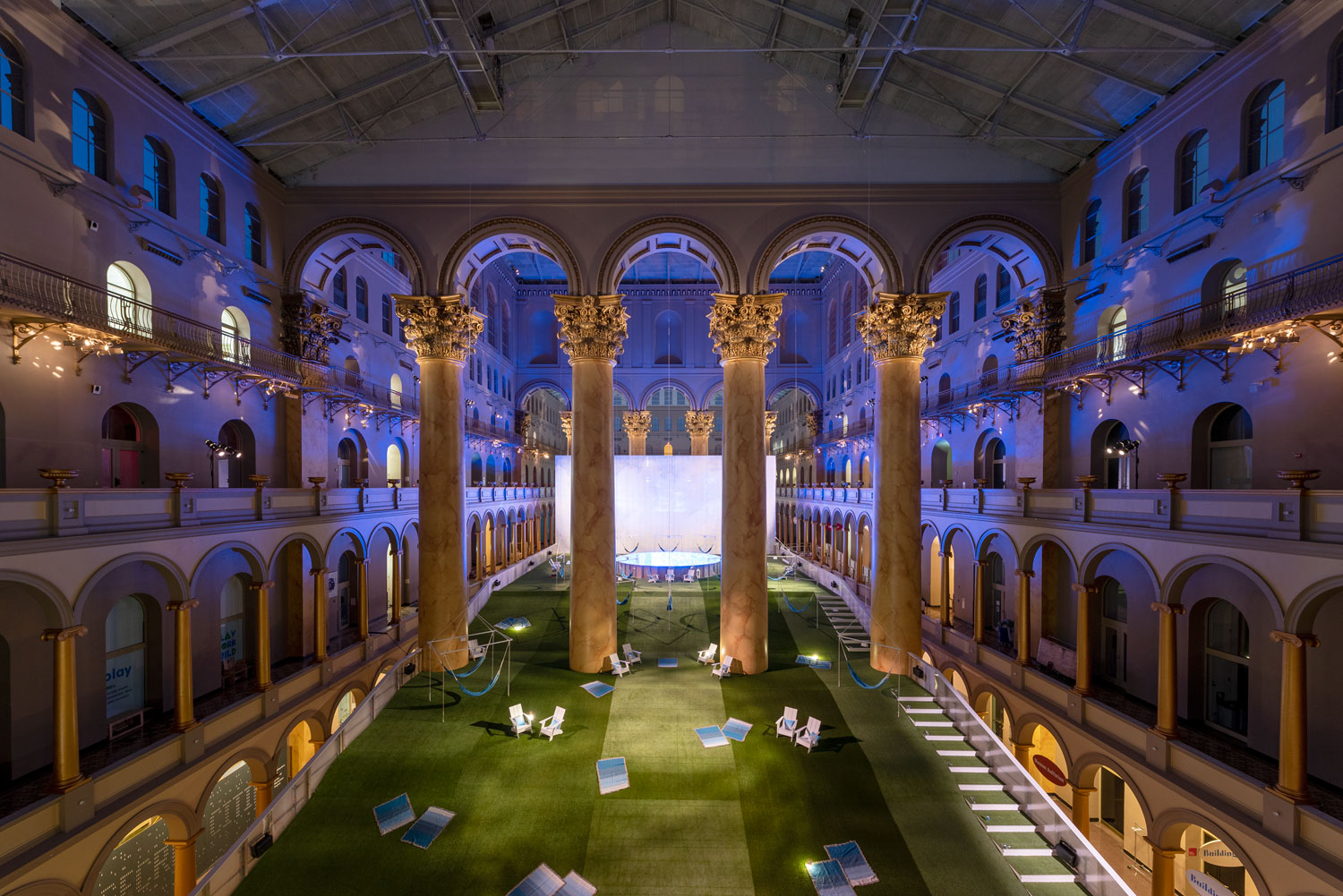 Inside of the National Building Museum, a lawn weaves between great pillars