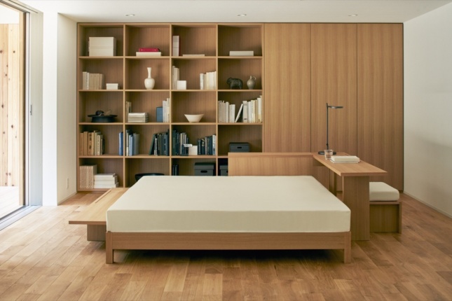 Inside a timber house, with a bed and Muji products on the walls