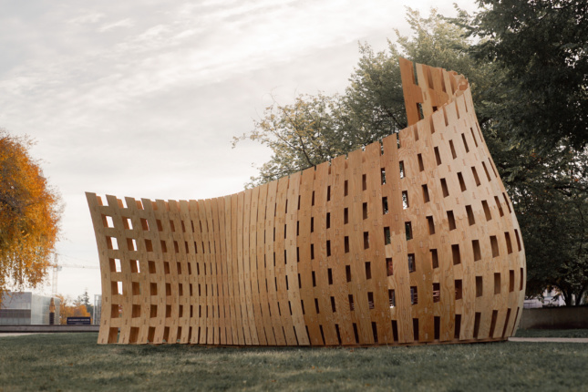 Photo of an upwardly cascading wall assembled from timber slats