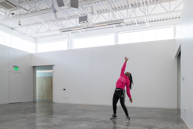 Interior photo of a woman dancing inside of a bare studio in the ArtLab
