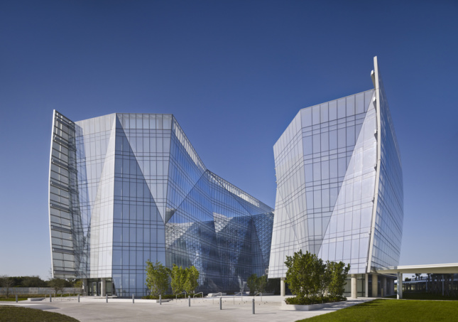 Exterior view of sharply shaped glass building with angular volumes