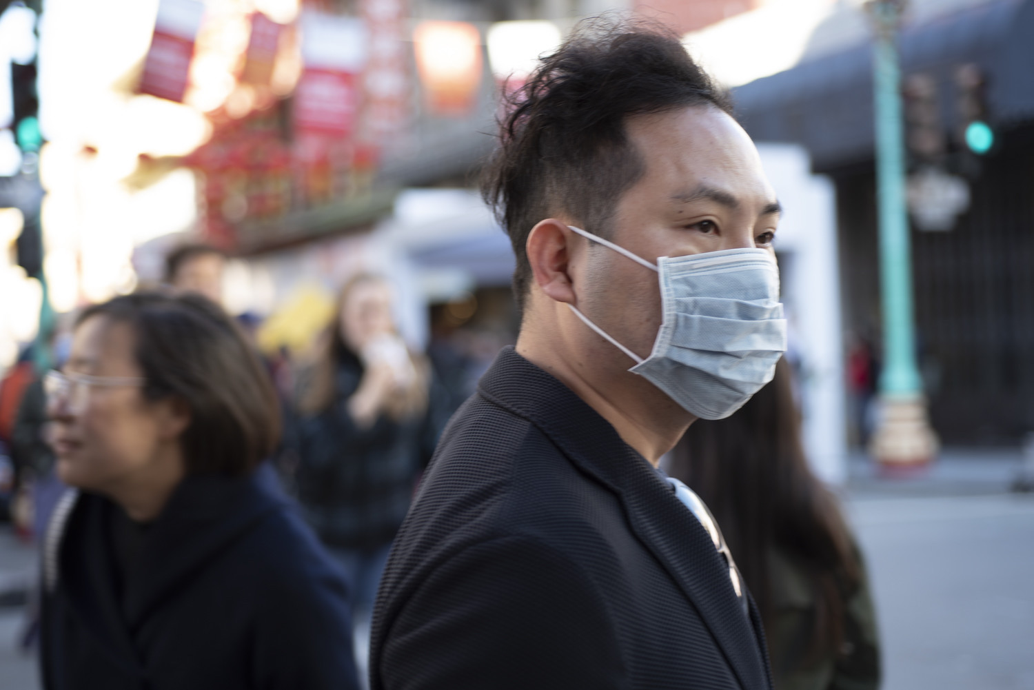 a man on the street wearing a respirator mask. Many popular events have been rescheduled due to coronavirus