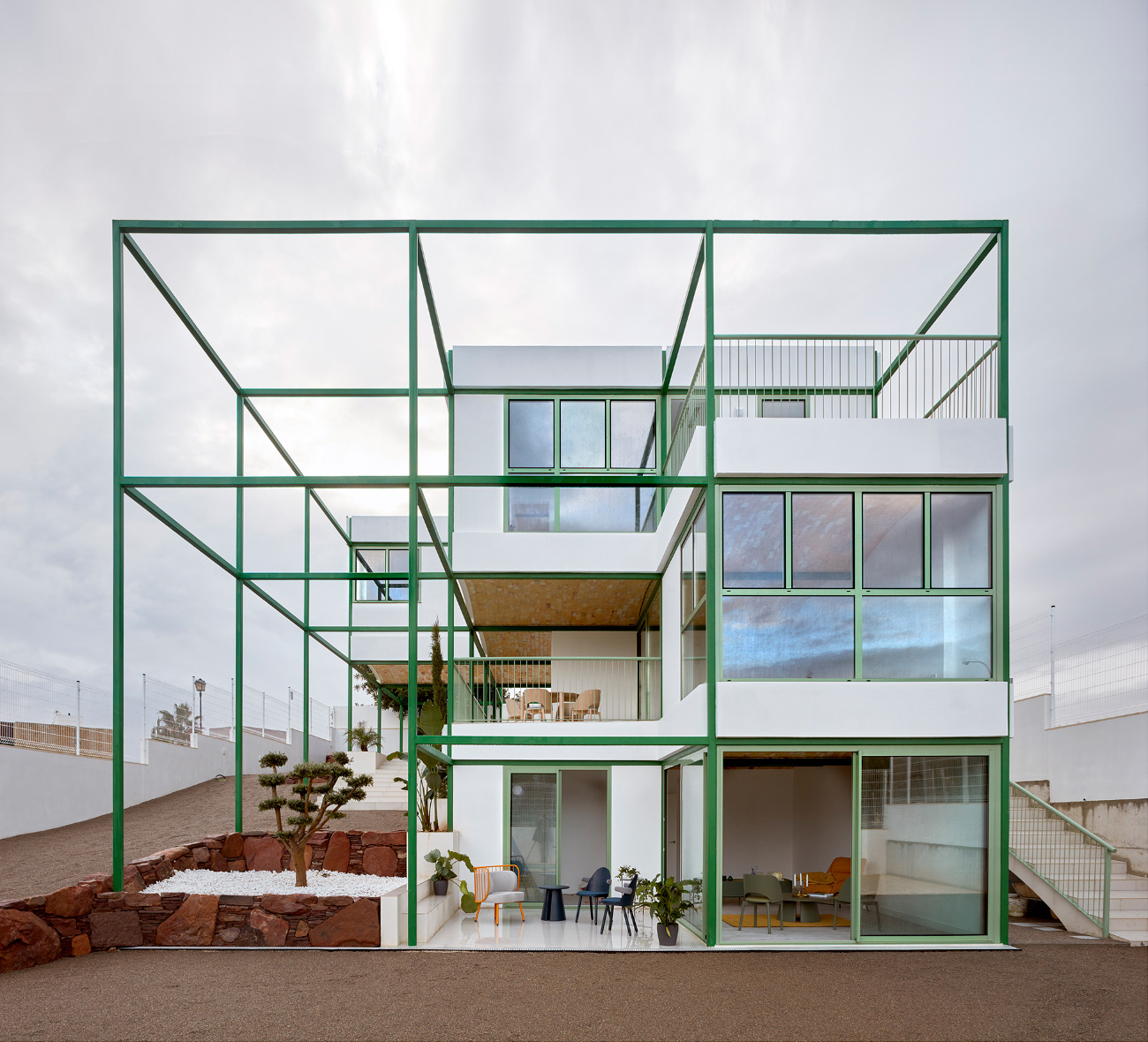 A home with a green metal grid surrounding it, designed by Space Popular