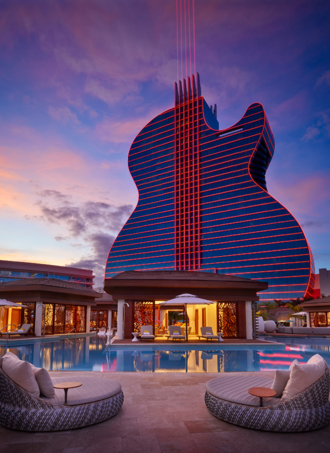 Photo of a towering Hard Rock Hotel shaped like a guitar, glowing at night