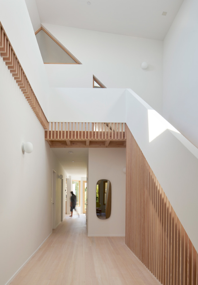 Interior of a white home with timber stairs, designed by an Emerging Voices winner