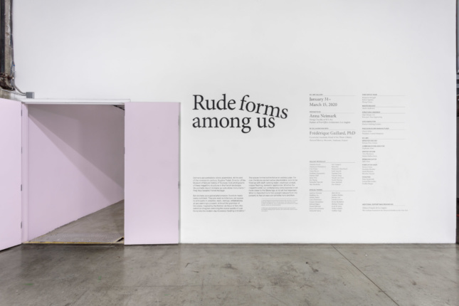 wall with text and door that reads "Rude Forms Among Us"