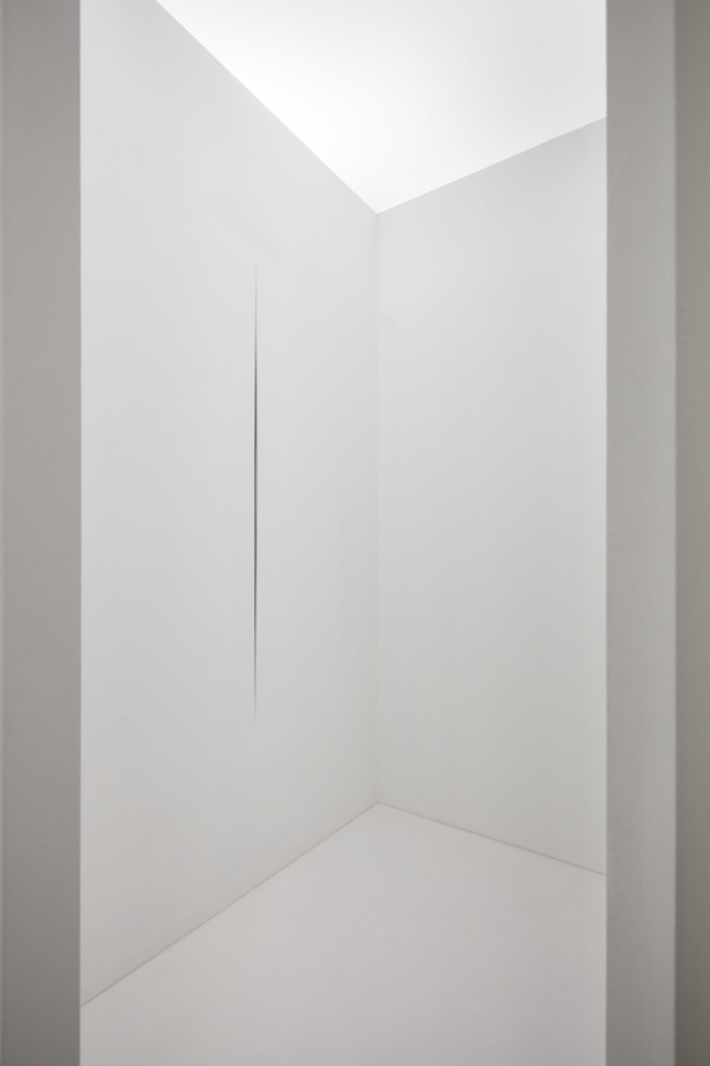 all-white room with a cut in the wall designed by Lucio Fontana