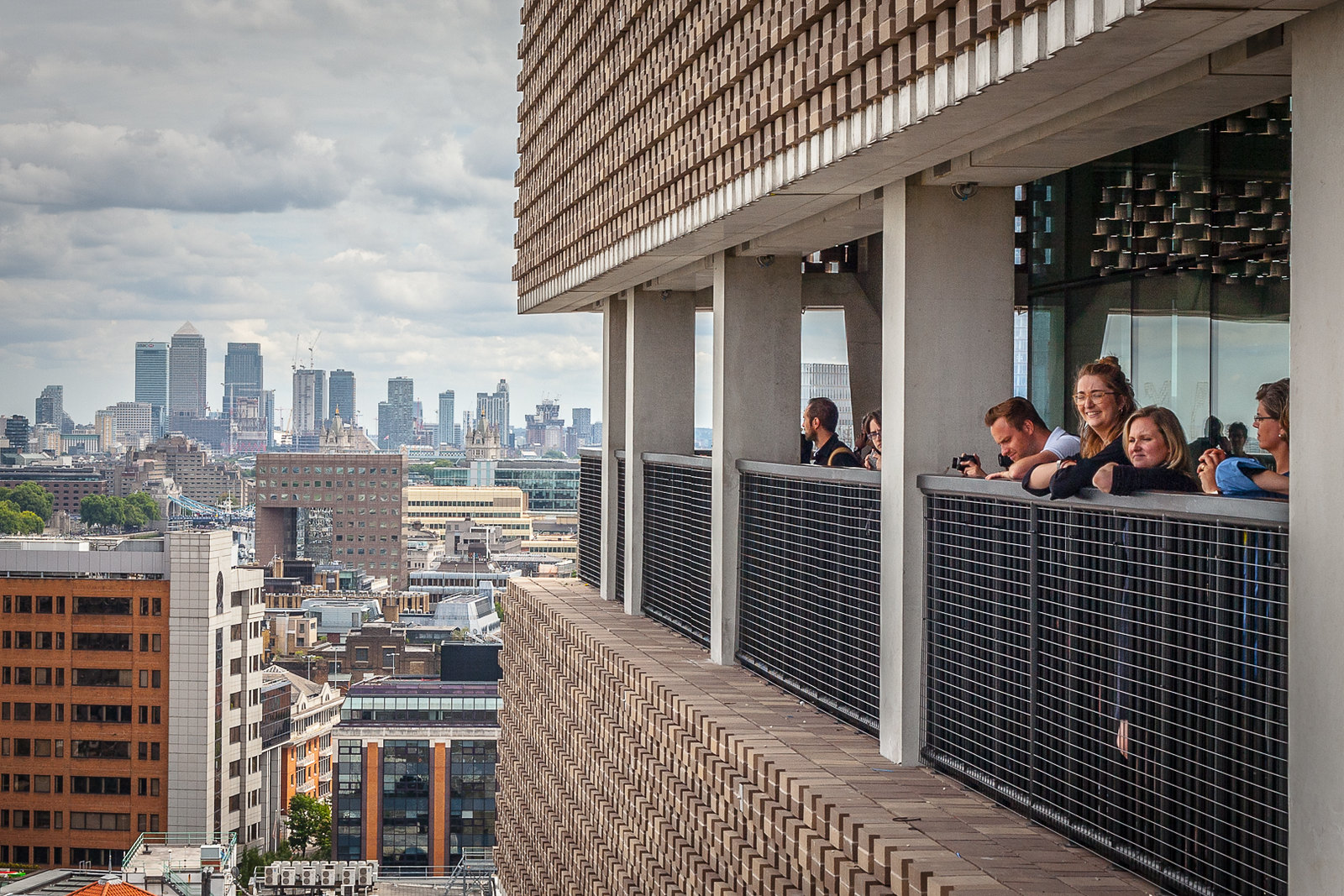 Balcony views at the Tate Modern in London, as people hang over the edge of a railing