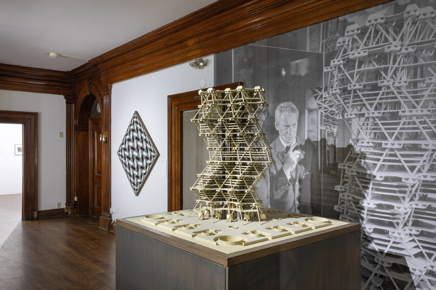Interior exhibition shot of a twisting wooden tower, on view in Invisible City