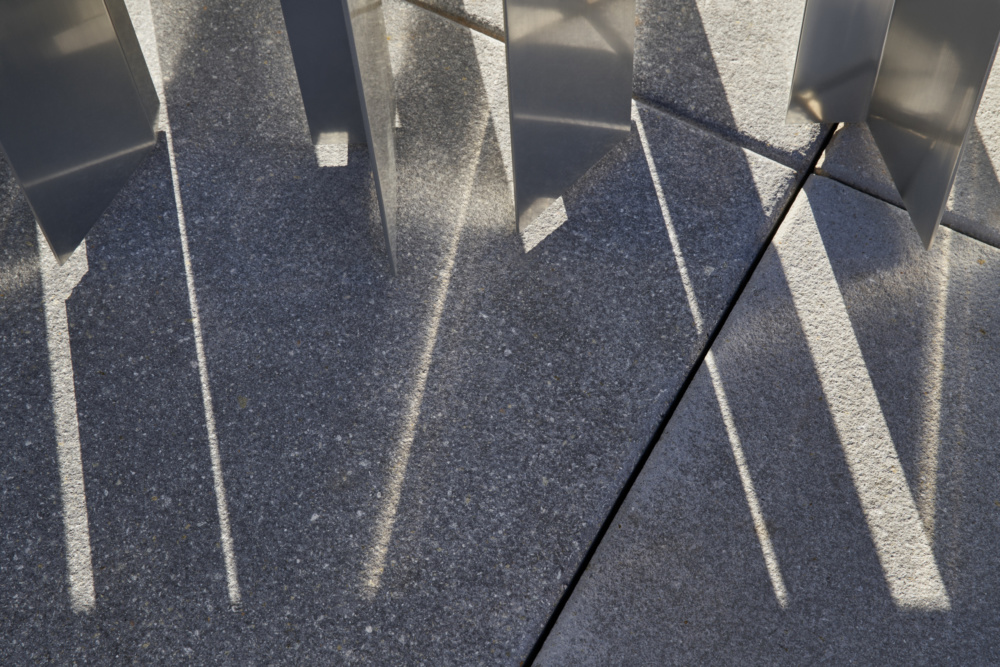 Detail of reflected light on facade bouncing off onto pavement