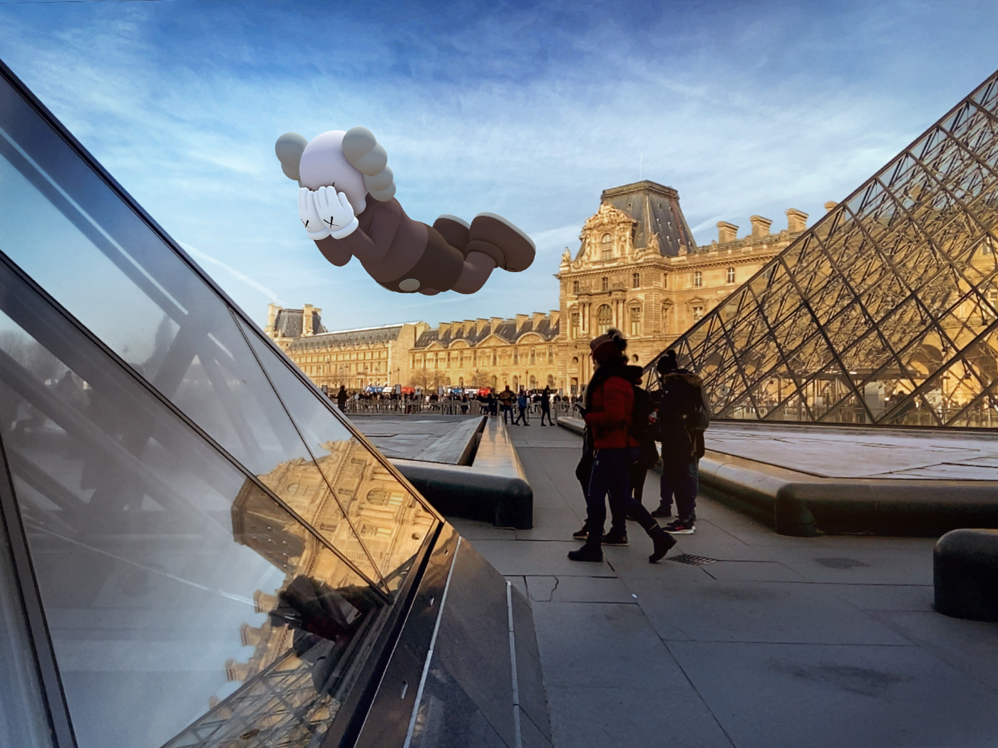 A KAWS bear floating above buildings and two people