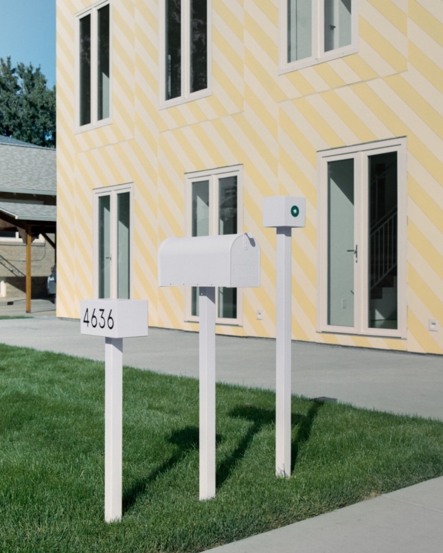 Mailboxes in front of a yellow home designed by Independent Architecture
