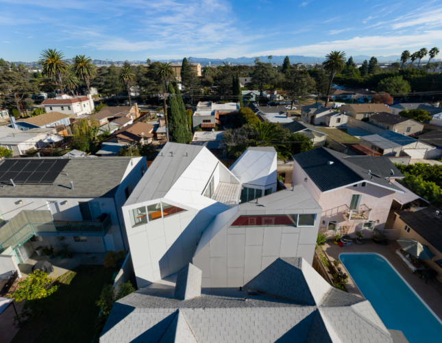 An aerial view of a white peaked home turned inward