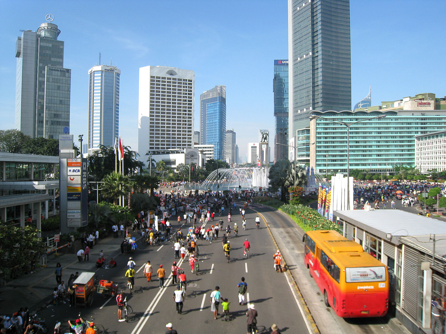 People on street with skyscrapers in the distance; Jakarta, Indonesia