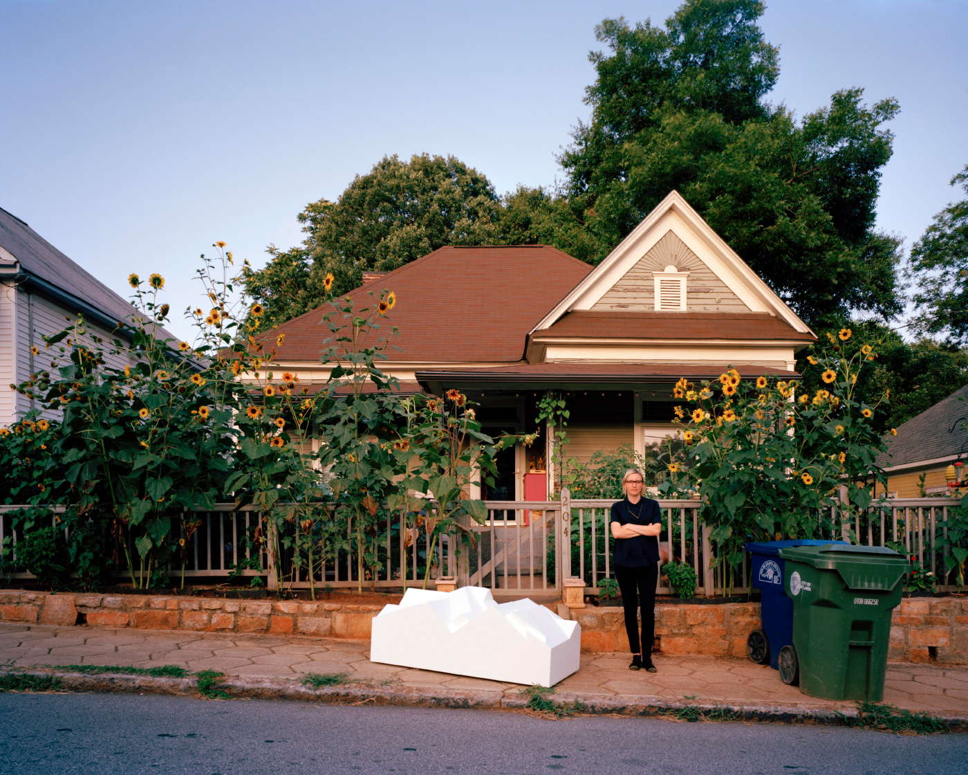 A photo of Jennifer Bonner and a gabled housing model on the sidewalk