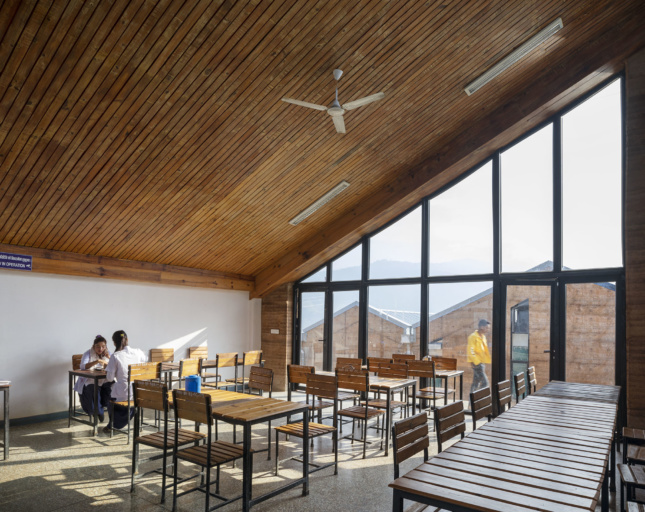 Interior of a slanted-roof classroom with mountain views