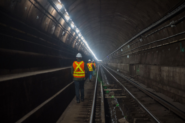 Construction workers walking through the L Train tunnel