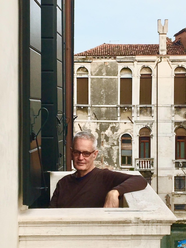 William Menking leaning on a balcony
