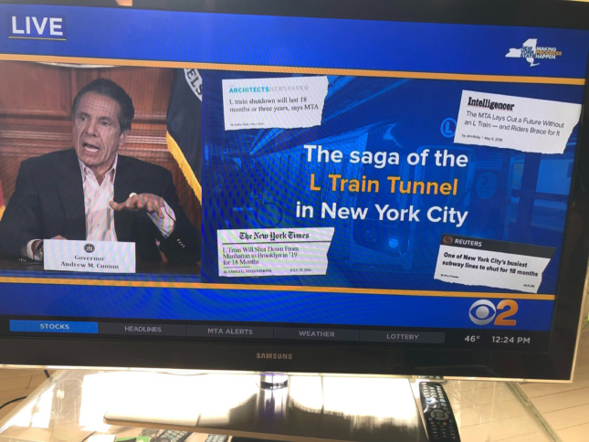 Andrew Cuomo presenting a slide with an AN article on it