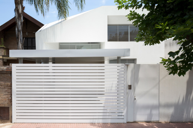 Exterior of a white home with vertically-oriented slits on the facade