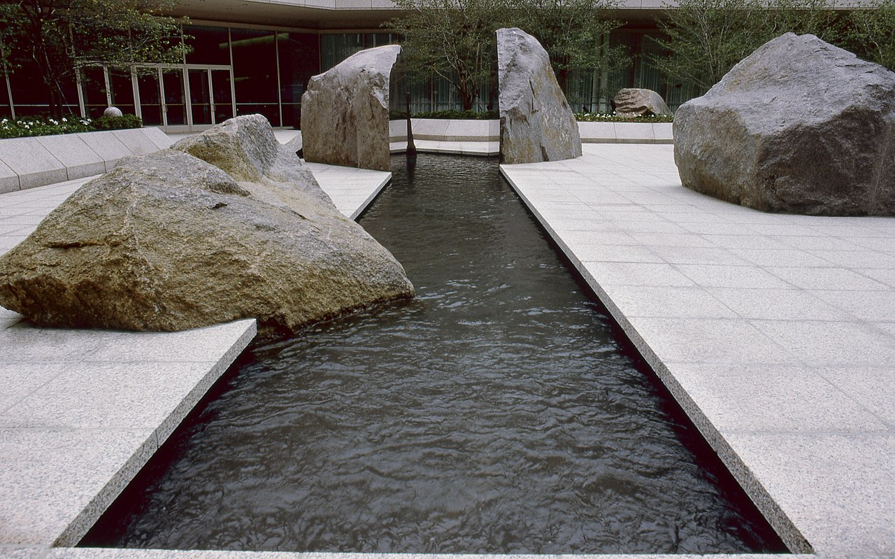 a sculptural installation arranged around a reflecting pool