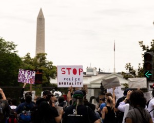 protesters marching against racial injustice with washington monument in background