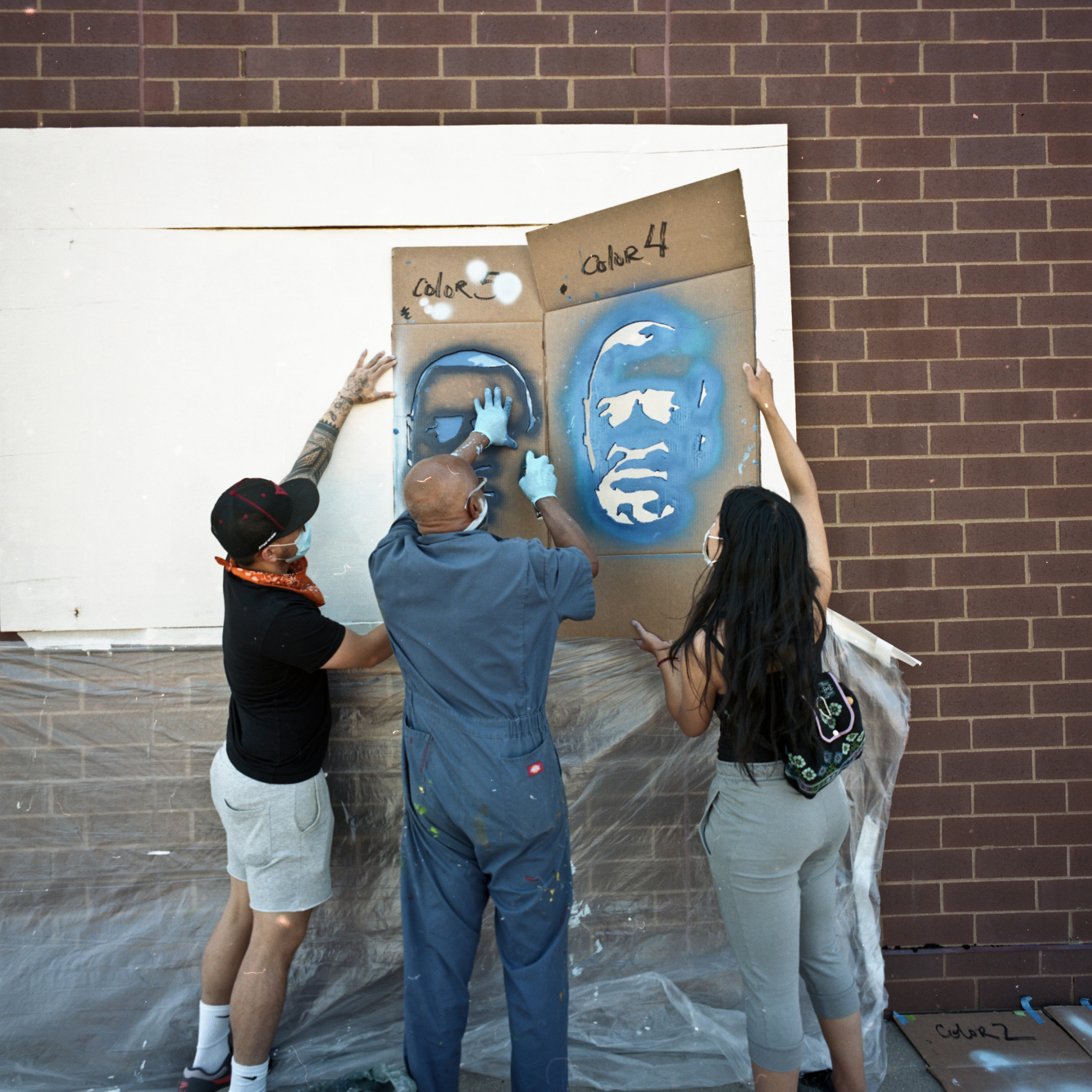 Students spraying a stencil onto the wall