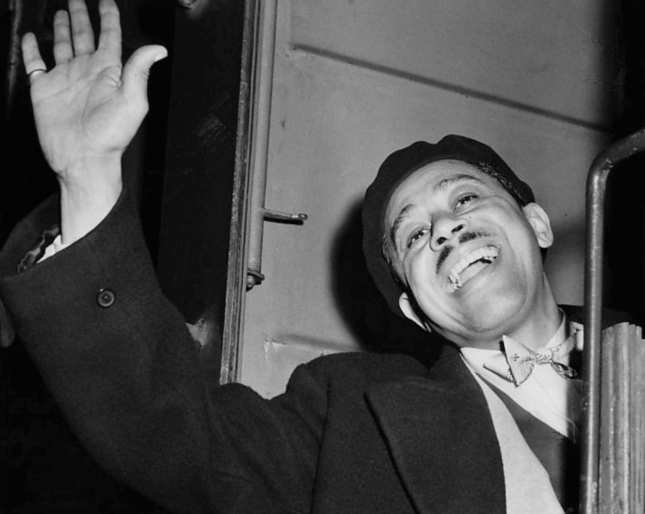 Black and white photo of cab calloway, a man with a mustache waving