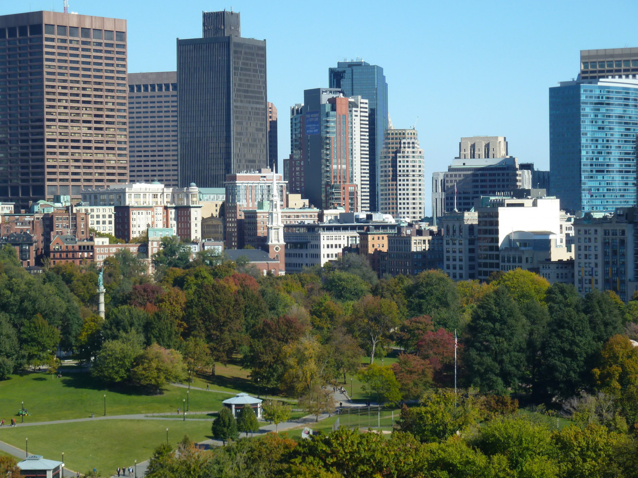 a city park with a skyline in the background; boston common