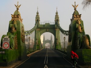 a cyclist exits hammersmith bridge in london