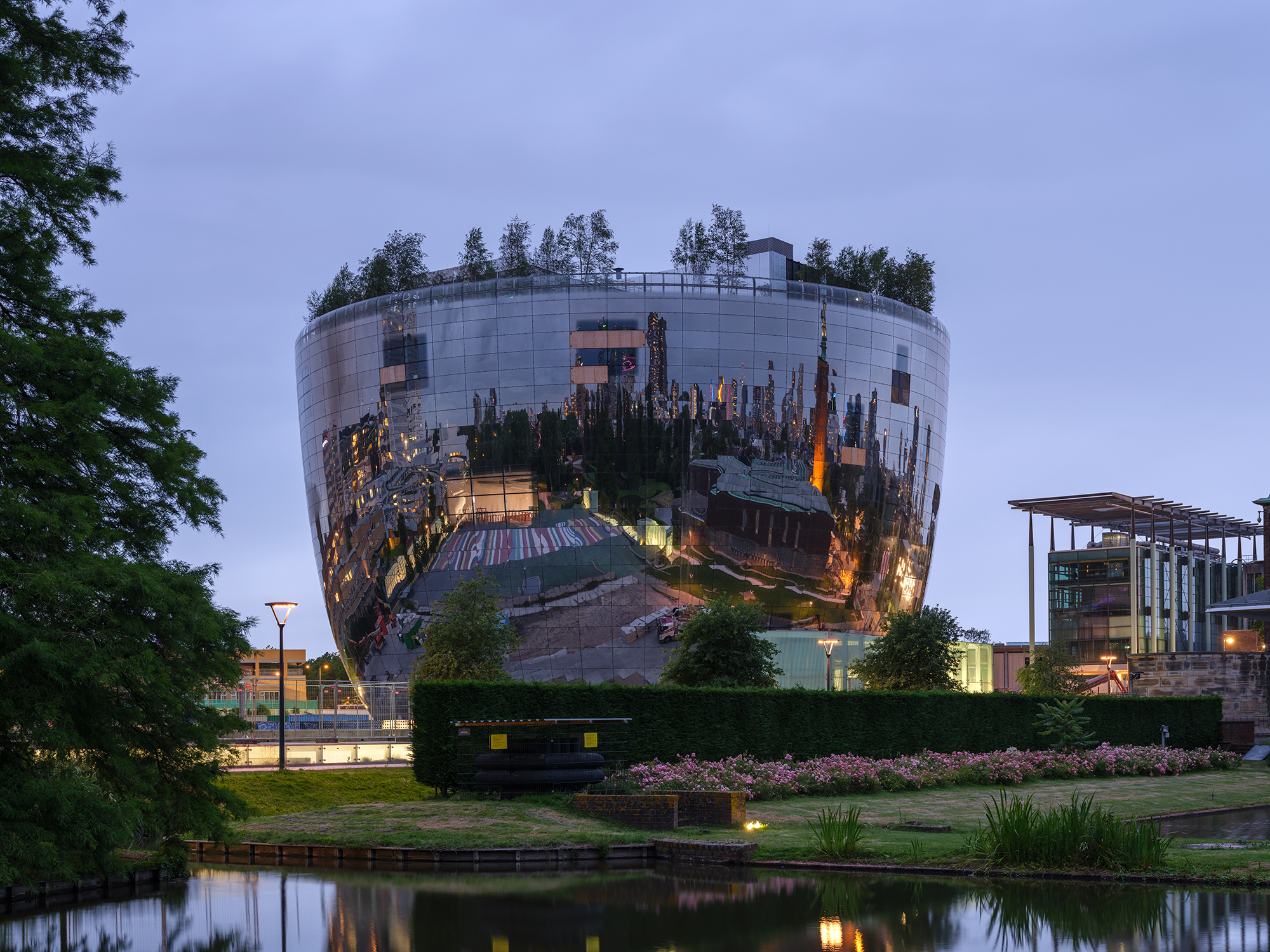 a mirrored, bowl-shaped building in the netherlands at night,, actually an art depot