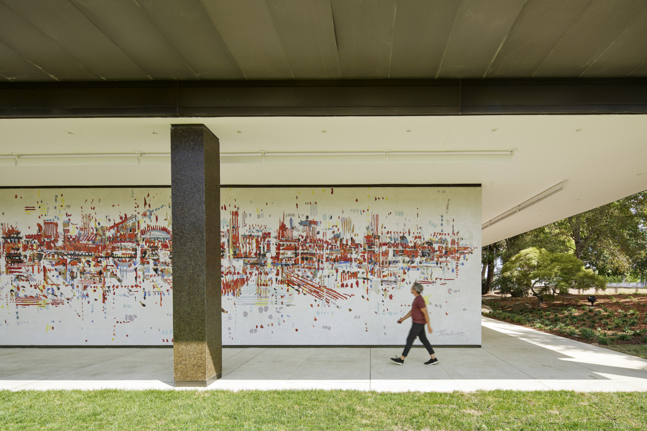 a person walks in front of a large, colorful mural at the SMUD headquarters