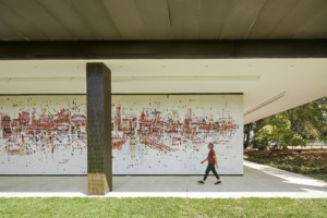 a person walks in front of a large, colorful mural at the SMUD headquarters