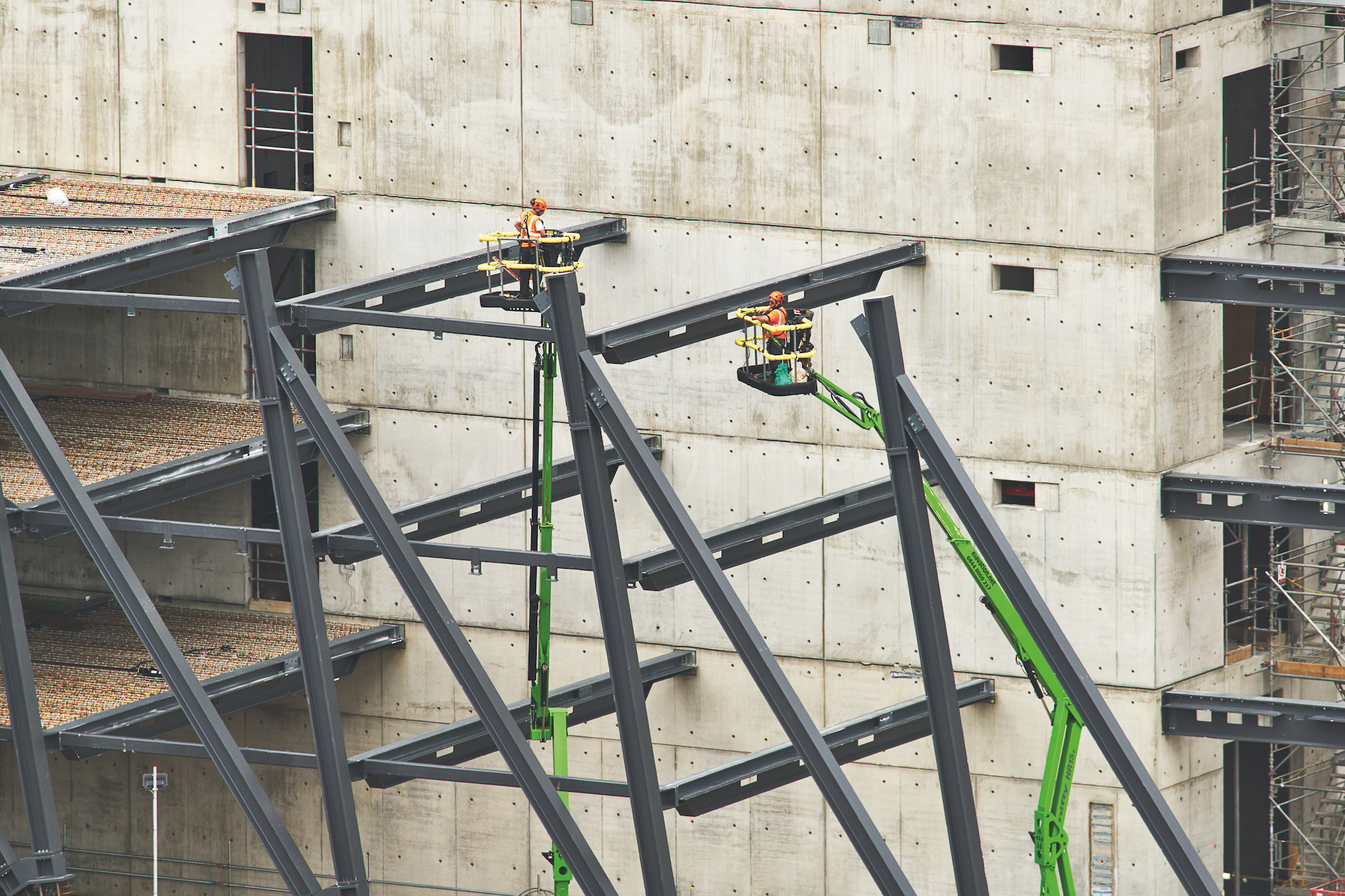 Construction image of beam and exoskeleton installation at a blank concrete wall
