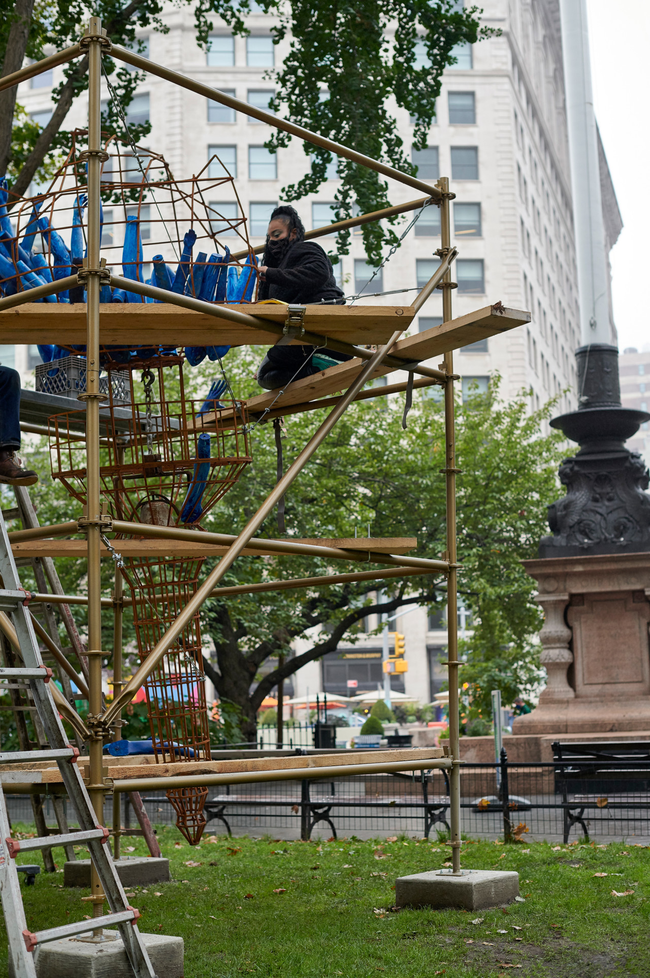 the artist installing light of freedom atop the piece's scaffolding