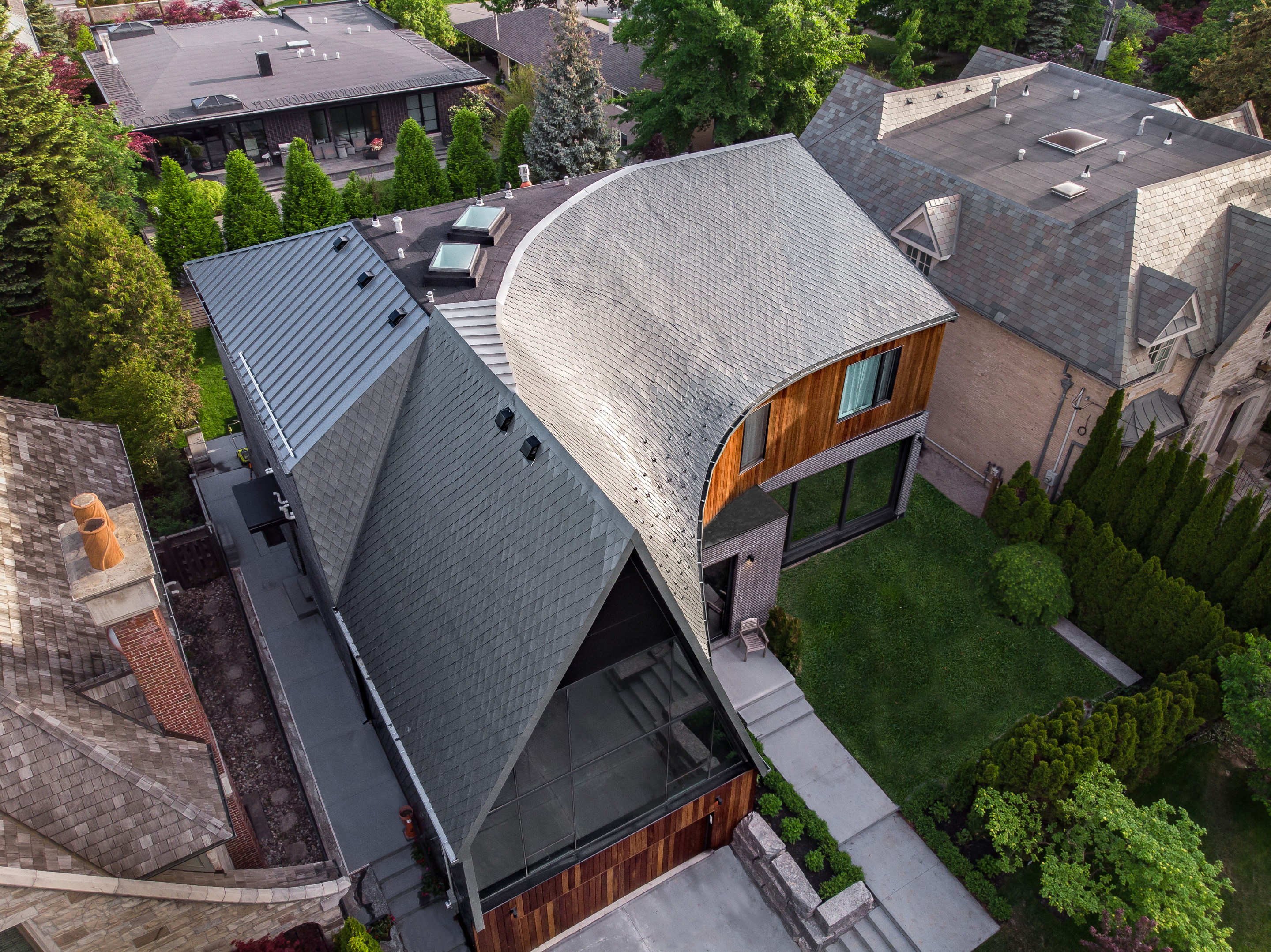 a home from above with a twisting, curving zinc roof